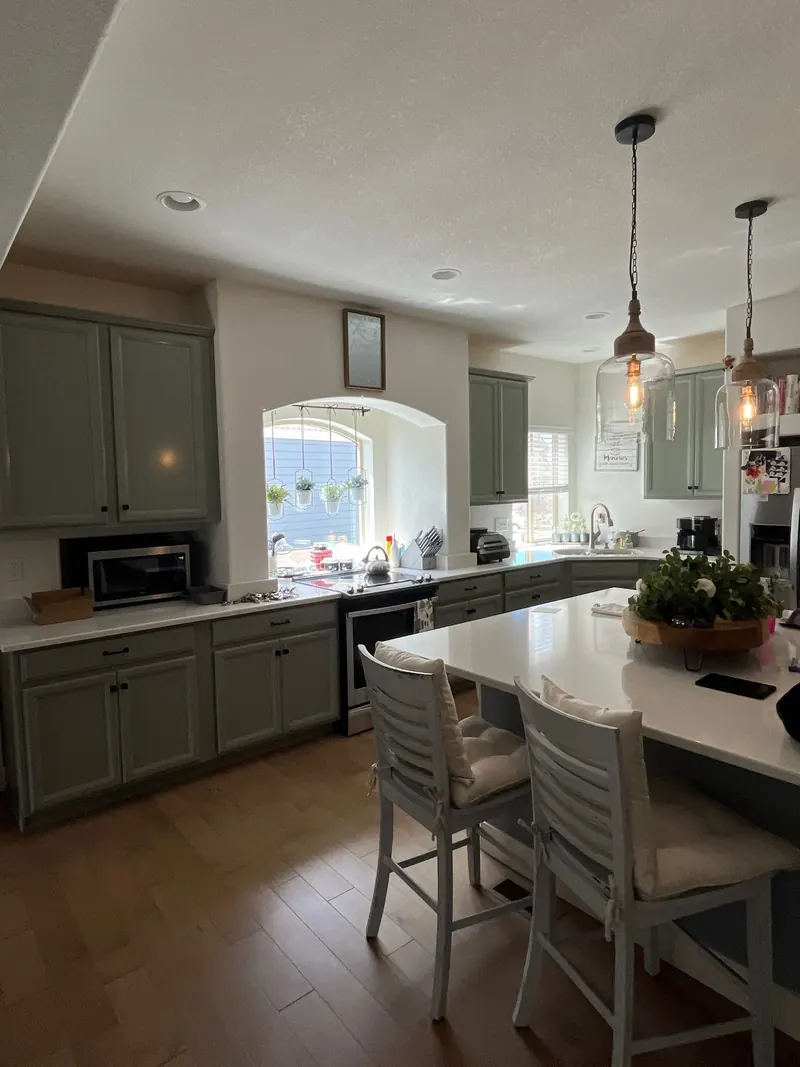 Repainted sage green kitchen cabinets with island seating